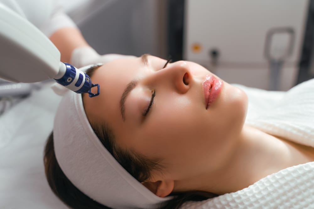 A woman receives laser treatment of the face in a cosmetology clinic