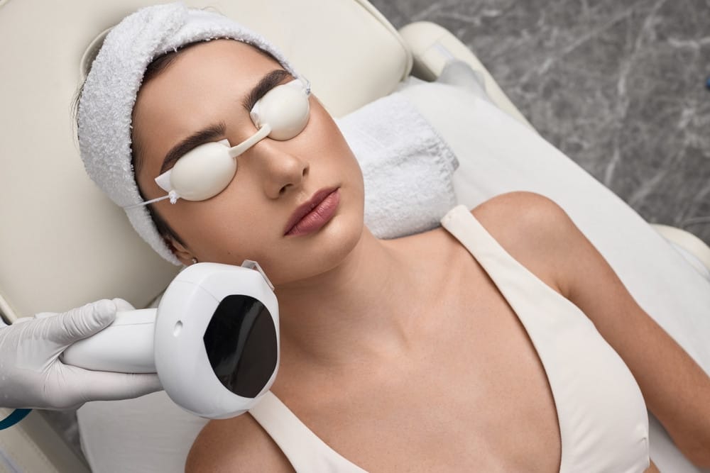 Female patient while photorejuvenation procedure with intense pulsed light IPL at dermatology office