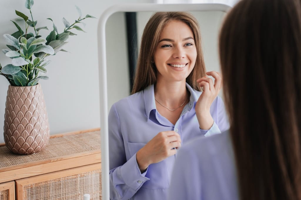 Woman smiling at her reflection in a mirror