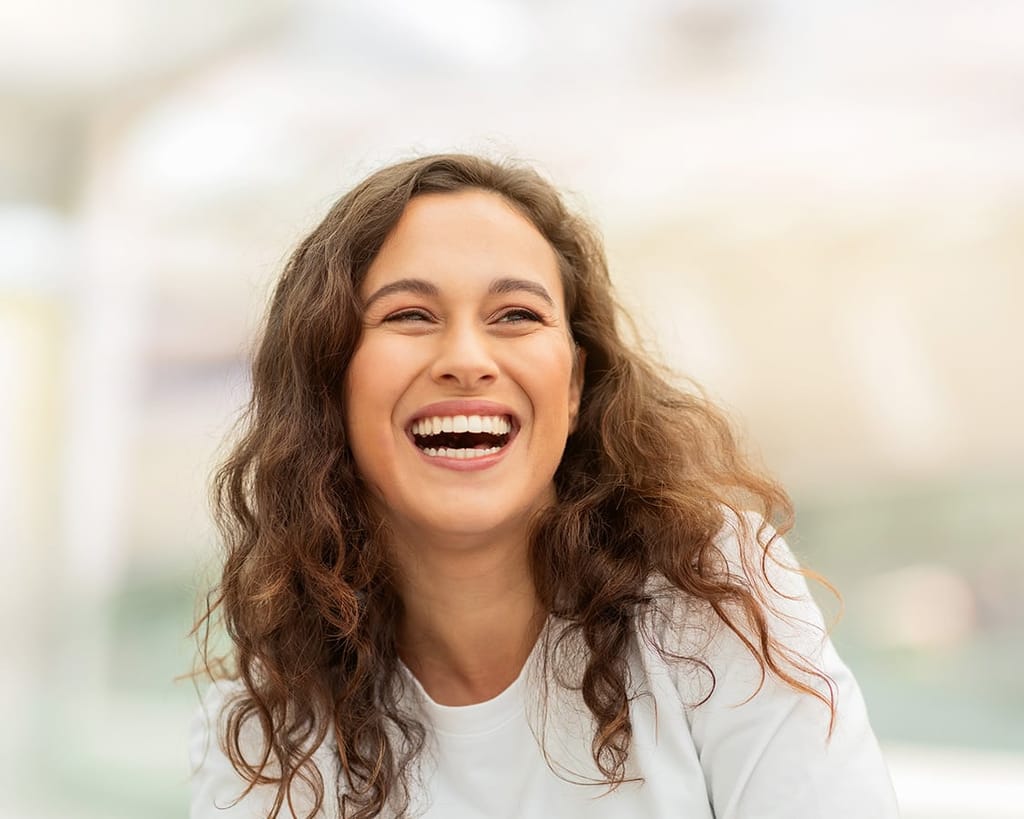 Joyful woman laughing after medical aesthetic treatment