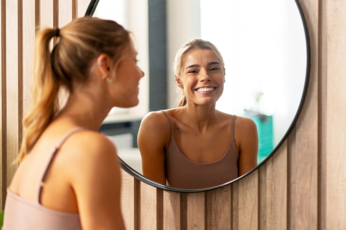 woman looking in mirror body positivity