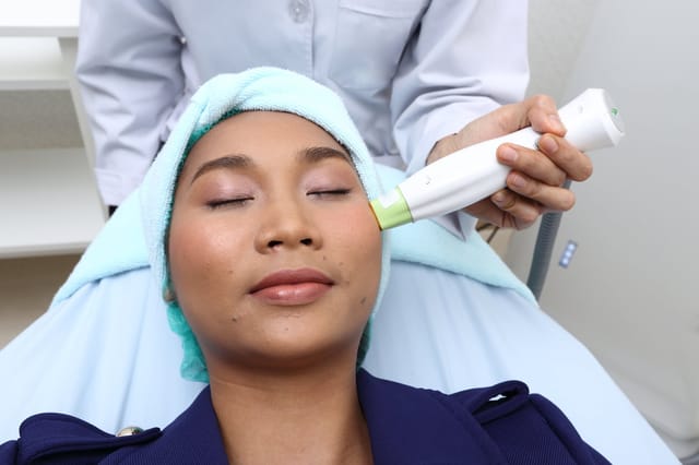 Treatment on Asian Woman as patient to make skin smooth bright and cure acne with medical beauty device instrument advance on face in hospital clinic