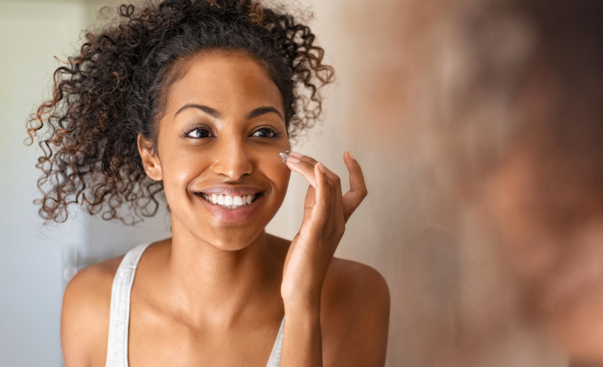 Woman applying moisturizer to her face